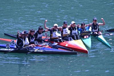 選手がカヌーに乗って肩を組んで集合している写真